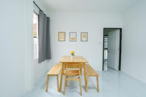 einen Tisch und Stühle in einem Zimmer mit einer weißen Wand in der Unterkunft ME House Banchang in Ban Chang
