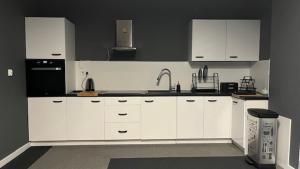 a kitchen with white cabinets and a sink at Apartamenty Marciniak in Puławy