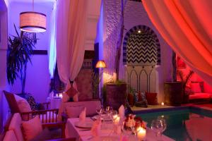 ein Esszimmer mit einem Tisch und einem Pool in der Unterkunft Riad Dar Alfarah in Marrakesch + 37 Fotos