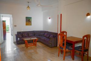 a living room with a purple couch and a table at Akhenaten Apartments in Luxor