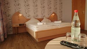 a bedroom with a bed with a bottle on a table at Ostseehotel Kappeln by team SchleiFee in Kappeln
