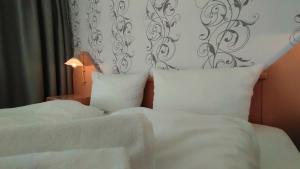 a bedroom with two beds with white sheets and a headboard at Ostseehotel Kappeln by team SchleiFee in Kappeln