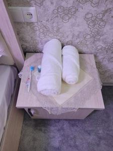 サマルカンドにあるApartment on Shahi Zindaのベッド横のテーブルに巻き上げたトイレットペーパー