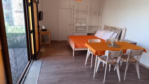 a room with a bed and a table and chairs at Sunlite Summer Cottages in Obzor