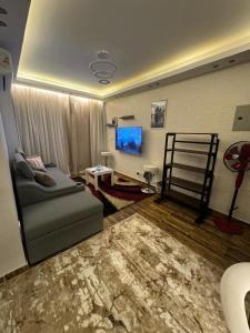 un salon avec un canapé et une télévision à écran plat dans l'établissement Madinaty - 2 BedroomBeauty, à Madinaty