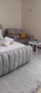 a large bed in a living room with a couch at Kathryn's Cosy Homes in Nairobi