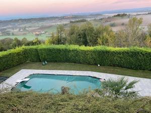 a small swimming pool in a yard with a hedge at Tenuta Paradiso del Monferrato in Portacomaro +22 photos