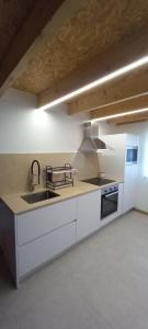 a large kitchen with a sink and a stove at Casa da Igreja-Abadim in Cabeceiras de Basto