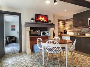 a kitchen with a table and chairs and a fireplace at Gîte Quai N 10 in Saint-Valery-en-Caux