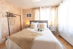 a bedroom with a large white bed and a window at Maison Chaleureuse avec parking gratuit sur place in Illkirch-Graffenstaden