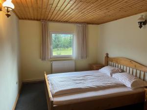 a bedroom with a large bed with a window at Casa Mărioara in Şirnea