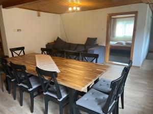 a wooden table and chairs in a room with a couch at Casa Mărioara in Şirnea