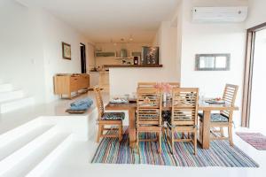 ein Esszimmer mit einem Holztisch und Stühlen in der Unterkunft Casa Blanca - Vista espetacular no coração do Arraial d'Ajuda in Arraial d'Ajuda