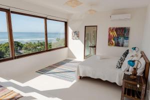 ein Schlafzimmer mit einem Bett mit Blick auf das Meer in der Unterkunft Casa Blanca - Vista espetacular no coração do Arraial d'Ajuda in Arraial d'Ajuda