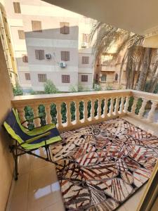 ein Balkon mit einem Stuhl und Blick auf ein Gebäude in der Unterkunft Beautiful Old Apartment in Madinat Al Ashir min Ramadan