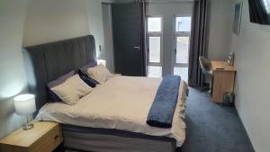 a bedroom with a bed with a headboard and a window at Marble Blue in Cape Town +61 photos