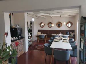 a dining room with a table and chairs and mirrors at The Rez Guesthouse in Walvis Bay