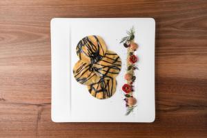 a white plate with food on top of a table at Hotel Girlanerhof in Appiano sulla Strada del Vino