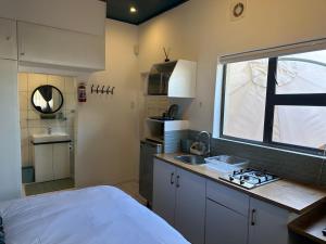 a small kitchen with a sink and a stove at Private Cottage on Alamein in Cape Town