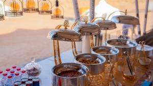 a table topped with containers of food and bottles of water at Infinity Camp in Bidiyah