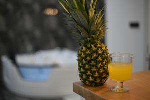a pineapple sitting next to a glass of orange juice at New Moment Lux in Žarkovo