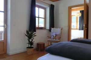 une chambre avec un lit, une chaise et une fenêtre dans l'établissement Bett & Berge - Ferienwohnung in den Schlierseer Bergen, à Schliersee 21 autres photos