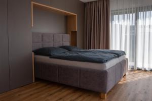 a bedroom with a large bed with a large window at Villa Studenec in Banská Štiavnica