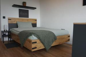 ein Schlafzimmer mit einem Holzbett mit einer Decke darauf in der Unterkunft APART LIVING Sindelfingen near to Daimler in Sindelfingen