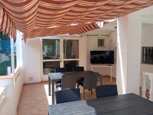 jadalnia ze stołem i krzesłami pod markizą w obiekcie Villa Benucia family guest house w mieście La Nucía