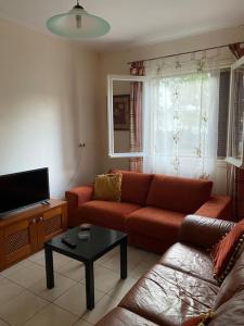 a living room with a couch and a tv at Sandras apartment in Igoumenitsa