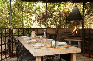 a wooden table with chairs and a fire place at Villa Oasi in San Vito lo Capo