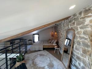 a room with a bed and a stone wall at La parenthèse in Millau