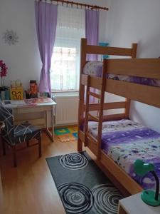 a bedroom with a bunk bed and a desk at Apartman NADA in Krapina