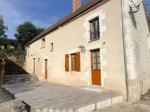 a building with a wooden walkway in front of it at Gîte du Riou in Bué