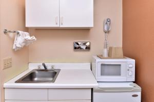 Una pequeña cocina con fregadero y microondas. en Golden Eagle Motel, en Dorris