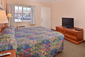 a hotel room with a bed and a flat screen tv at Golden Eagle Motel in Dorris