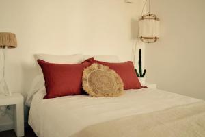 a bed with red and white pillows at Logement avec jardin à 200m de la digue in Wimereux +5 photos