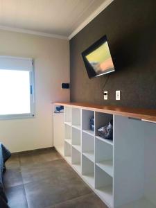 ein Wohnzimmer mit einem Fernseher an der Wand in der Unterkunft PH SomoS in San José