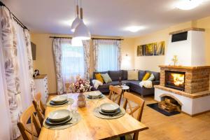 a living room with a table and a fireplace at e-Pagony Dunakanyar- Privát erdei szállás in Kismaros