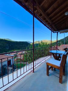 a patio with a table and a bench on a balcony at Forrest Guesthouse in Polídhroson