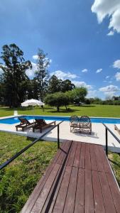 a wooden deck with two picnic tables and an umbrella at Posada Los Molles in Colón