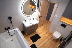 a bathroom with a tub and a sink and a mirror at Villa Studenec in Banská Štiavnica +17 photos