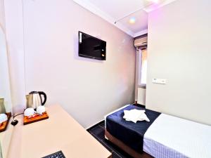 a room with a bed and a desk and a tv at Diamond Hotel in Istanbul