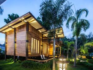 ein kleines Holzhaus mit einer Palme in der Unterkunft The Cottage Aonang in Ao Nang Beach + 16 Fotos