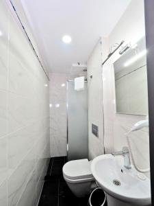 a white bathroom with a toilet and a sink at Diamond Hotel in Istanbul +54 photos