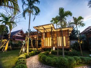 a wooden house with palm trees in front of it at The Cottage Aonang in Ao Nang Beach