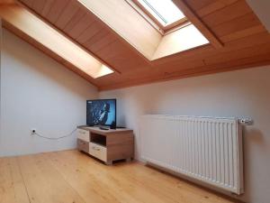 a living room with a skylight and a television in a room at Vučko 454 Apartman in Jahorina