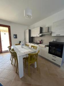 a kitchen with a white table and chairs in a room at Villa Orsola in Chia