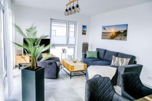 a living room with blue couches and a potted plant at Apartmenthaus Windland in Pouch