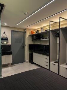 una cocina con armarios blancos y negros y una puerta en Flat 118 com Hidromassagem - get by side, en João Pessoa
